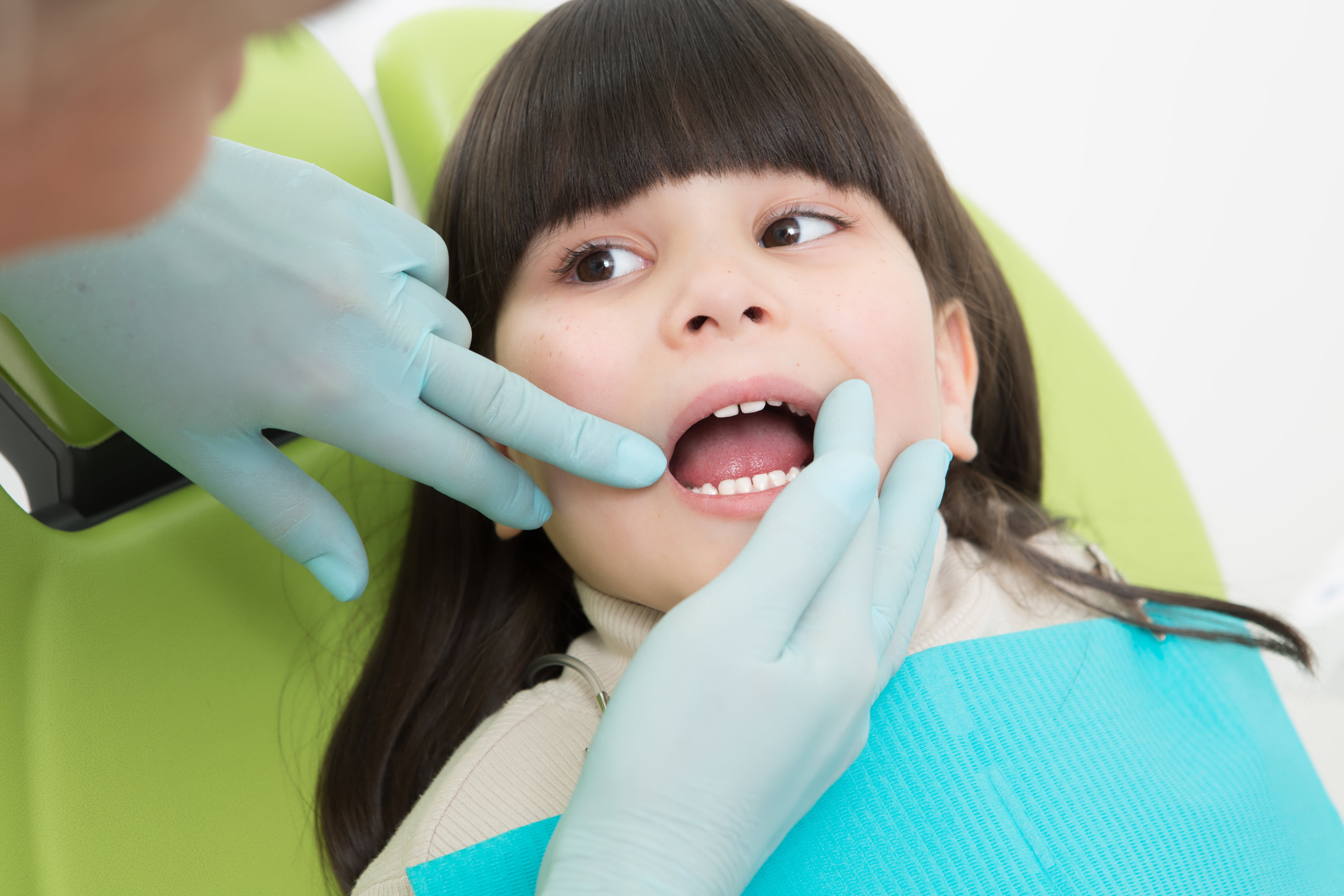close-up-little-girl-having-her-teeth-examined-by-dentist-min